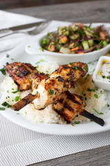 A view of a Mediterranean plate of chicken kabob, in a restaurant or kitchen setting.