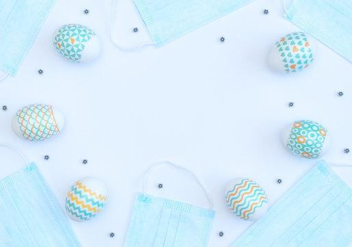 Decorated Easter eggs with medical face masks on white background with copy space. Happy Easter during quarantine concept. Biohazard, 2019-nCoV, COVID-19, social distance, stay home. Flat lay.