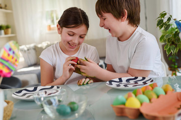 Beautiful children painting colorful eggs for easter holidays at home. Easter egg dyeing