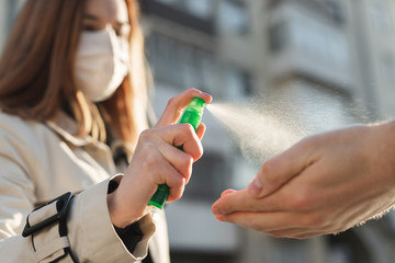 People who use alcohol-based antiseptic gel and wear a preventive mask prevent infection with the Covid-19 coronavirus outbreak, a woman washes a man's hands with hand sanitizer