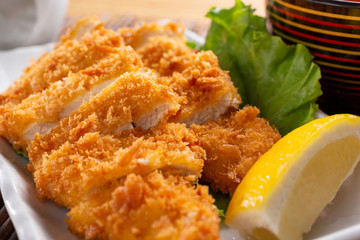 A closeup view of a plate of katsu chicken in a restaurant or kitchen setting.