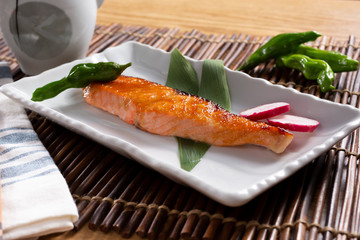 A view of a plate of Japanese salmon misoyaki, in a restaurant or kitchen setting.