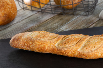 A view of a rustic sourdough baguette, in a restaurant or kitchen setting.