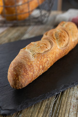 A view of a rustic sourdough baguette, in a restaurant or kitchen setting.