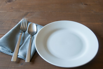 Empty dish with cutlery on a rustic wooden table