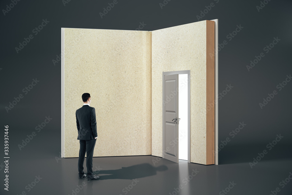 Poster businessman looking at abstract open book with door on gray background.