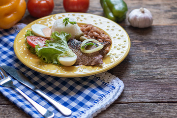 Brazilian food dish. Beans, rice, meat and salad.