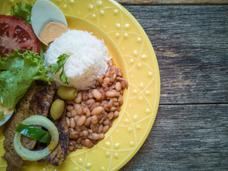Traditional Brazilian food dish. Beans, rice, meat and salad.