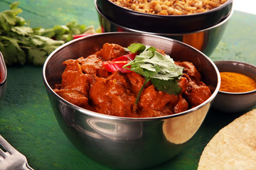 Chicken tikka masala spicy curry meat food in pot with rice and naan bread. indian food on table