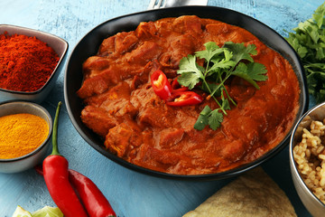 Chicken tikka masala spicy curry meat food in pot with rice and naan bread. indian food on table
