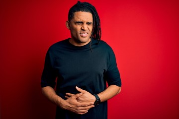 Young handsome african american afro man with dreadlocks wearing casual t-shirt with hand on...