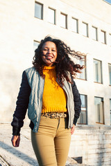 Fototapeta premium young pretty afican american girl happy smiling on city background, lifestyle people outside