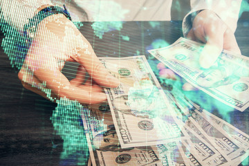 Multi exposure of financial theme drawing hologram and USA dollars bills and man hands. Business...