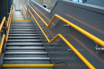 stairs with many steps and yellow railings in the subway