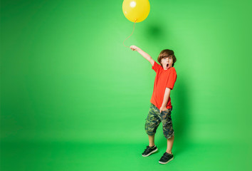 Fototapeta premium young boy holding a balloon with surprised expression