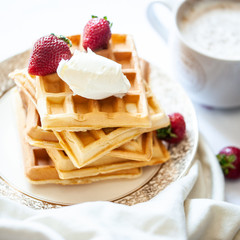 Torre de wafles con helado, frutillas y cafe