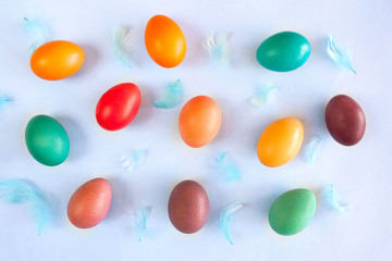 Easter composition with colorful Easter eggs and blue feathers