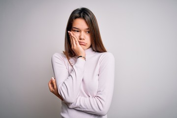 Young beautiful brunette girl wearing casual sweater standing over isolated white background thinking looking tired and bored with depression problems with crossed arms.