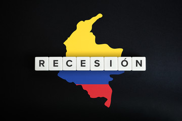 Colombia economic recession (recesion economica) caused by coronavirus crisis and covid-19 outbreak. Spanish text, Colombian flag and map on black background.