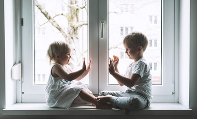 Little children on background of window at home