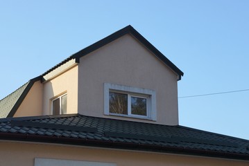 brown concrete loft with a white small window of a private house against a blue sky