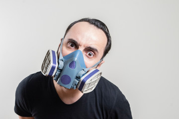 man in a protective mask and hat stands in a defense pose on a gray isolated background. Epidemic, quarantine, outbreak of Covid-19 coronavirus disease. Specialized infection protection