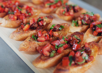 Tomato bruschetta served on toasted italian bread on a wooden board
