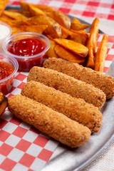 A closeup view of several deep fried mozzarella sticks, in a restaurant or kitchen setting.