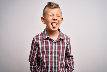 Young little caucasian kid with blue eyes wearing elegant shirt standing over isolated background sticking tongue out happy with funny expression. Emotion concept.