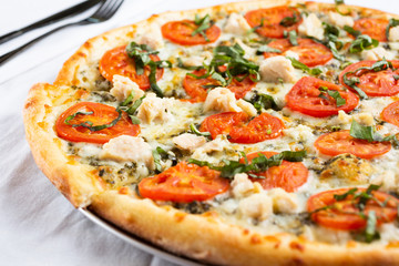 A view of a Margherita chicken pizza pie, in a restaurant or kitchen setting.