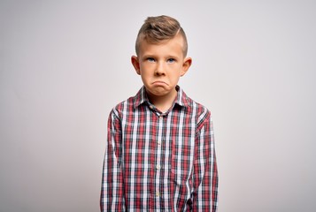 Young little caucasian kid with blue eyes wearing elegant shirt standing over isolated background depressed and worry for distress, crying angry and afraid. Sad expression.