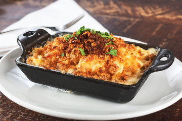 A view of a rustic crumble macaroni and cheese dish, in a restaurant or kitchen setting.