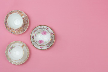 Pretty vintage china teacups on a pale pink background