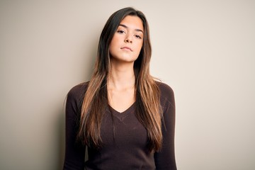 Obraz premium Young beautiful girl wearing casual sweater standing over isolated white background Relaxed with serious expression on face. Simple and natural looking at the camera.