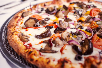 A view of a Mediterranean veggie pizza pie, in a restaurant or kitchen setting.