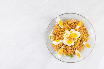 Cooked beans with rice salad served in the bowl decorated with eggs
