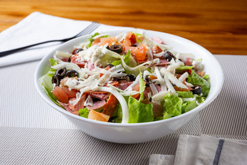 A view of a bowl of an antipasto salad, in a restaurant or kitchen setting.