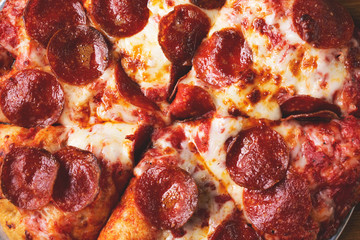 A top down view of a pepperoni pizza pie, as a background.