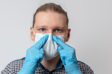 Guy puts on respiratory mask. Attractive man puts on face mask and looks at camera. Cold, flu,...