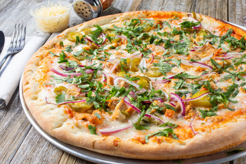 A view of a Mexican chicken pizza pie, in a restaurant or kitchen setting.