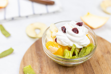 Fruit salad whipped cream flat lay white marble table