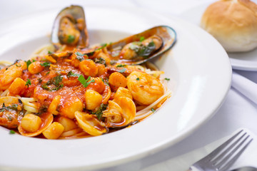 A view of a bowl of seafood linguine Italian dish, in a restaurant or kitchen setting.