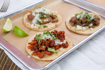 A view of a tray of street tacos, in a restaurant or kitchen setting.