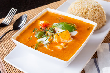A view of a bowl of Panang curry, in a restaurant or kitchen setting.