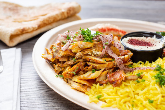 A View Of A Chicken Shawarma Plate, In A Restaurant Or Kitchen Setting.