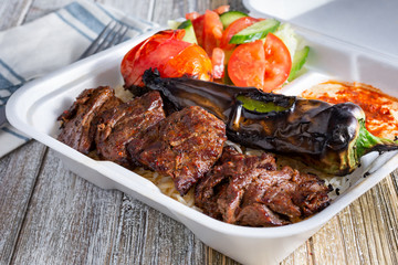 A view of a combo plate of Mediterranean beef shish kabob, in a restaurant or kitchen setting.