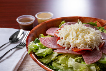 A view of an antipasto salad, in a restaurant or kitchen setting.