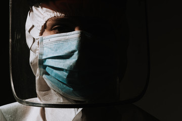 Female doctor with mask and face shield medical protective suit coronavirus covid-19 on black background - obrazy, fototapety, plakaty