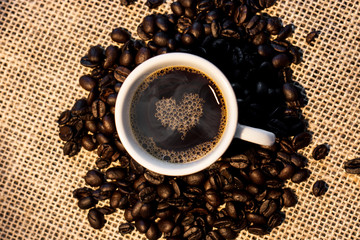Xícara de café com grãos de café na base.