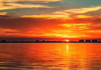 Indian Beach 6, Sarasota, Florida, beautiful red orange sunset, visible sun, water buildings, skyline, sun-stream , reflection